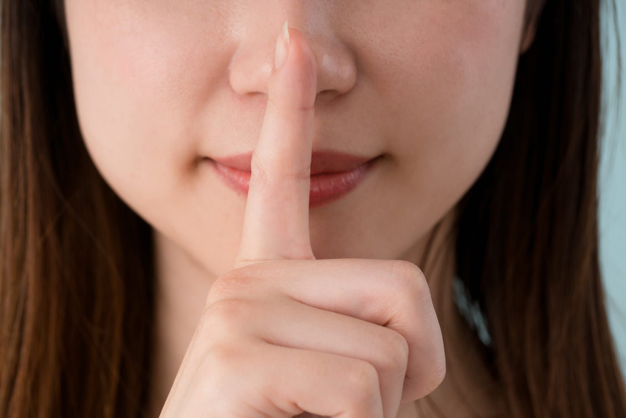 人差し指で「静かに」のジェスチャーをしている女性