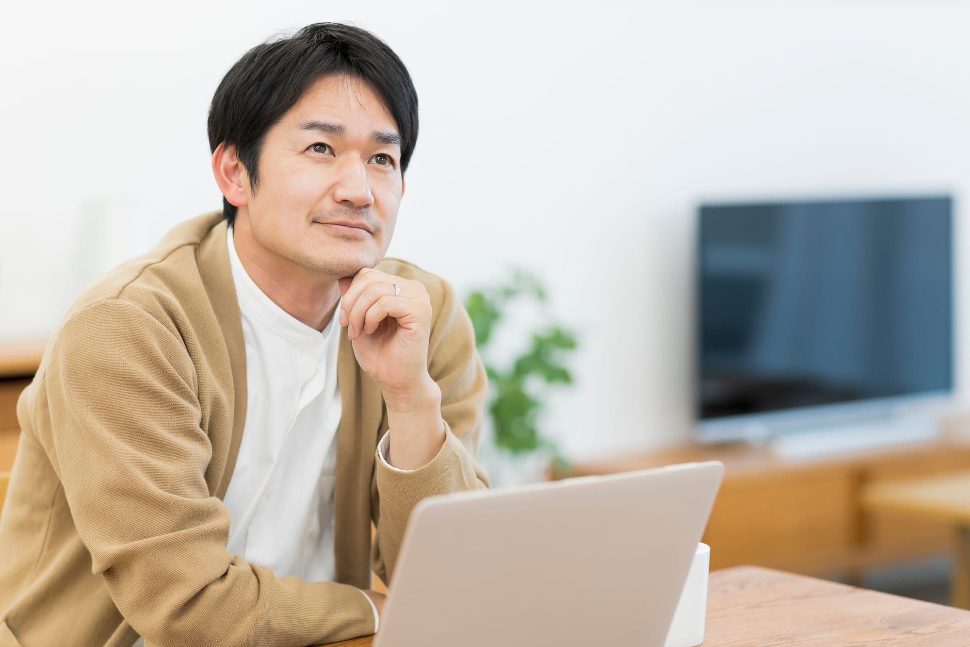 仕事中に考え事をしている男性のイメージ